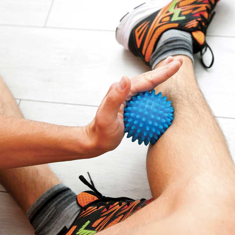 Personne se massant avec une balle de massage